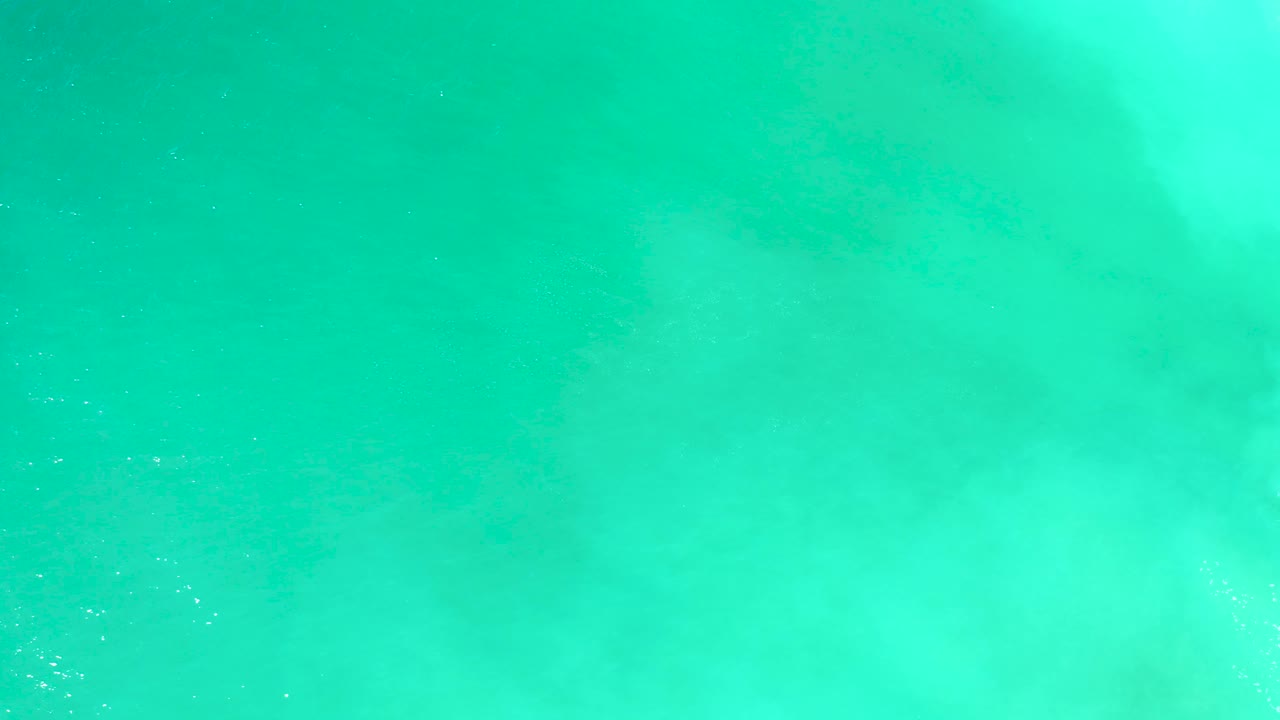 Clear aqua water at Dreams Los Cabos with broad pale underwater patches running diagonally and no visible people.
