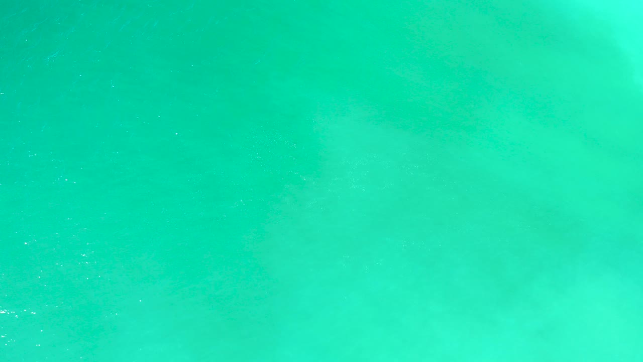Turquoise ocean surface with faint foam and bubbles