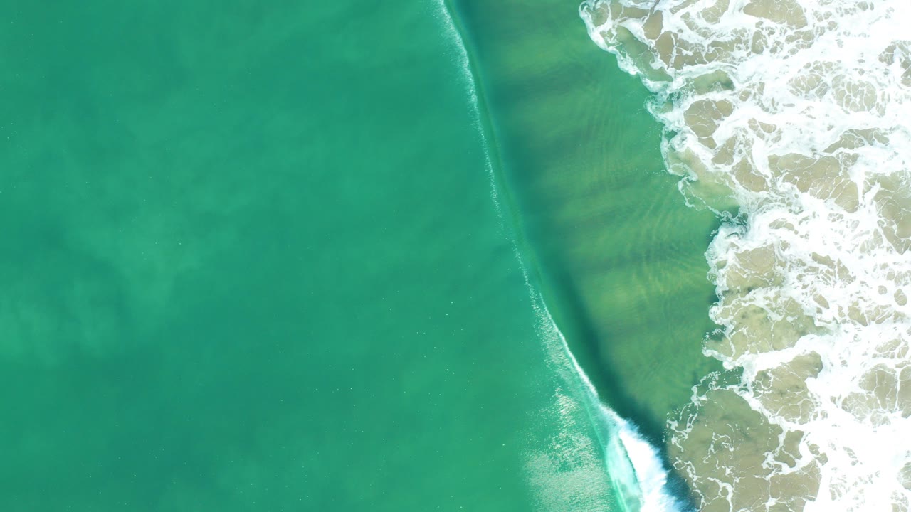 Overhead turquoise ocean with white surf along the right edge