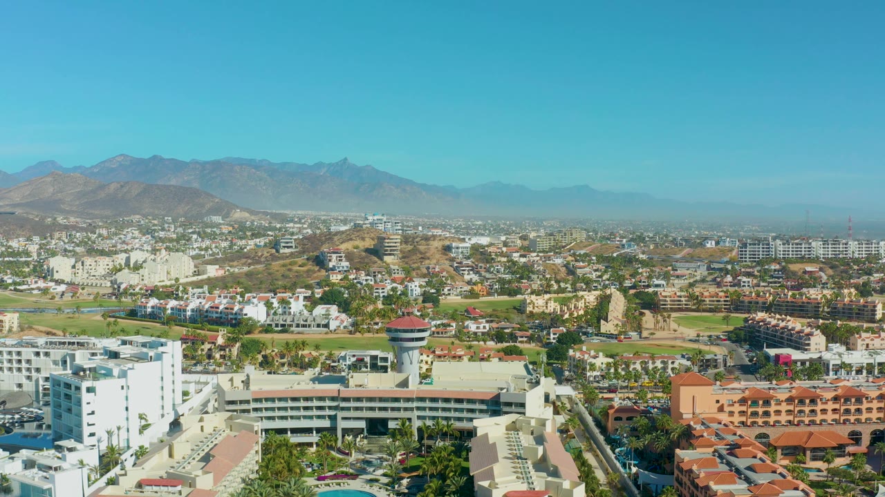 Elevated city view with white buildings and hazy mountains
