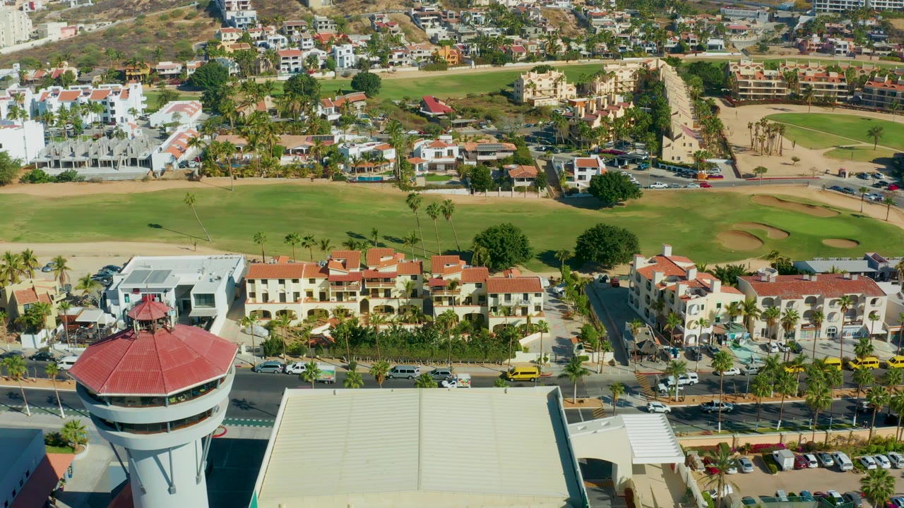 Golf course, homes, street traffic, and partial control tower roof