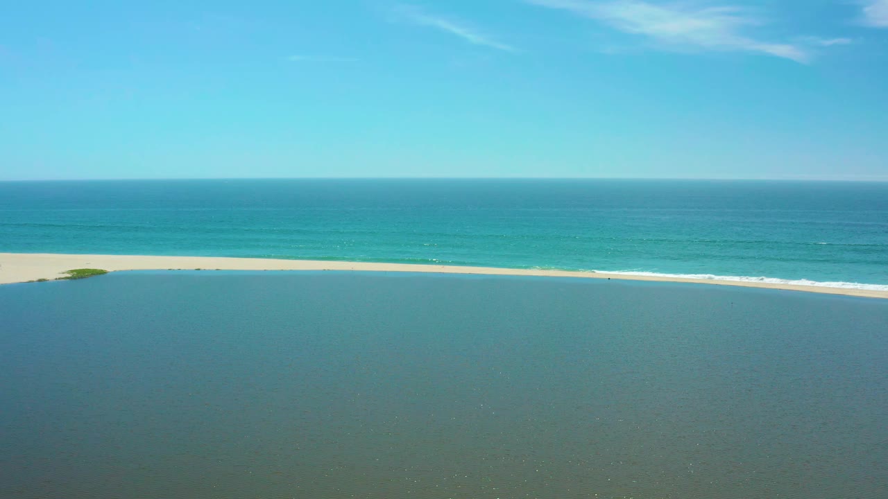Wide aerial of sandbar between lagoon and ocean