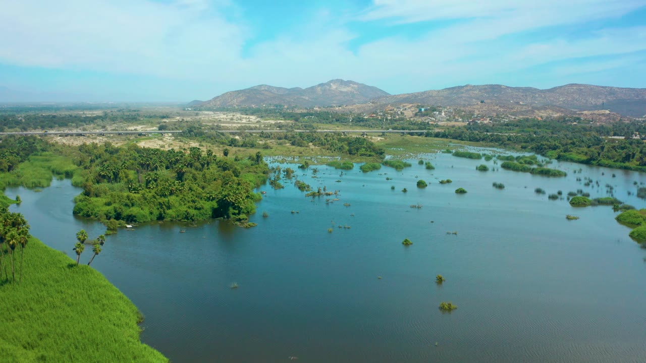 Aerial landscape with water, green island clusters, and hills