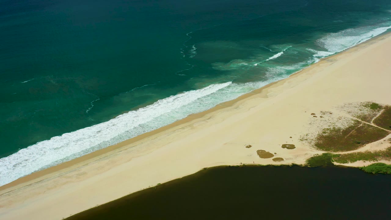 San Jose del Cabo aerial view with the surf line slightly farther along the beach, the lagoon dark at the bottom edge, and no visible people.