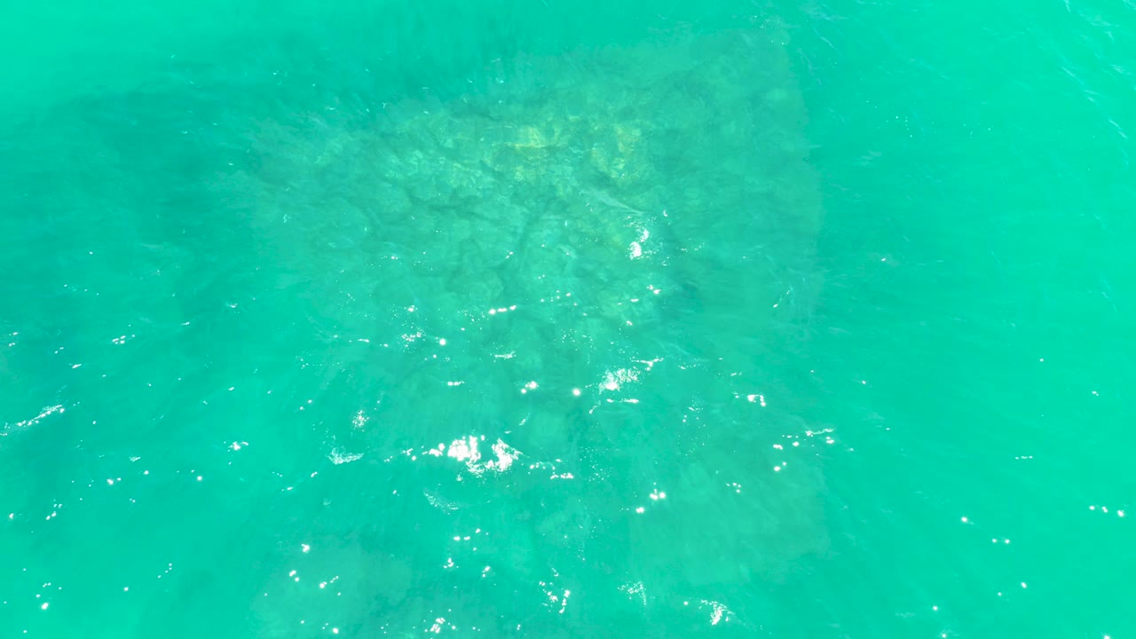 Turquoise water over a submerged rock formation
