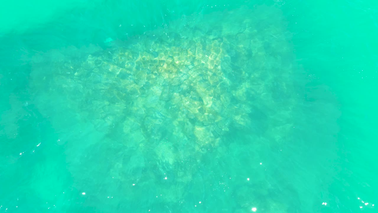 Clear water with rocks visible below.