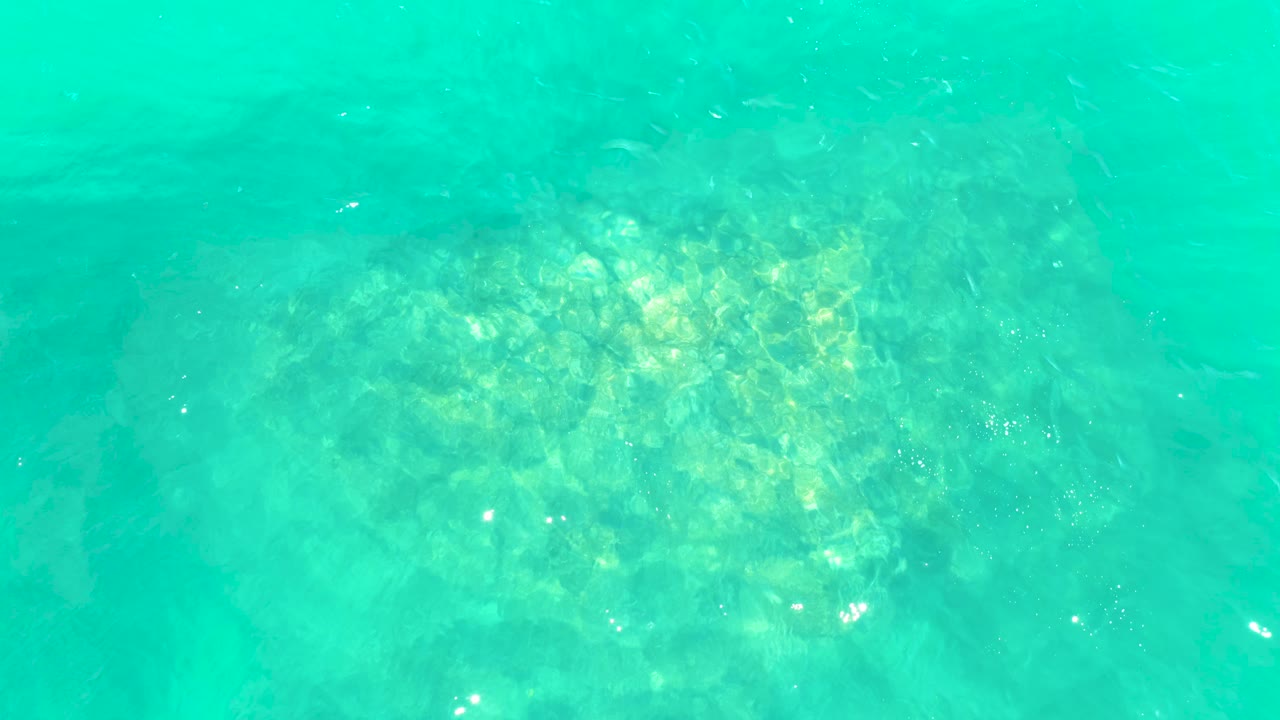 Shallow turquoise water with seabed rocks