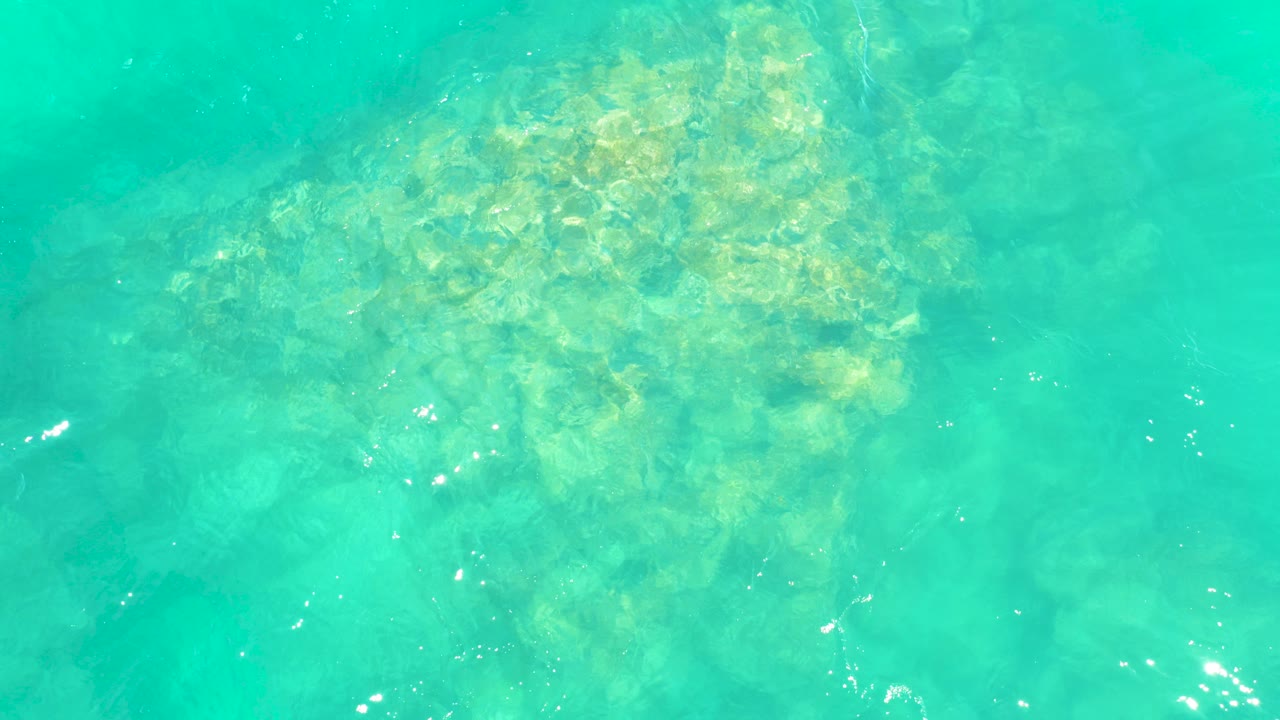Turquoise water over submerged rocks