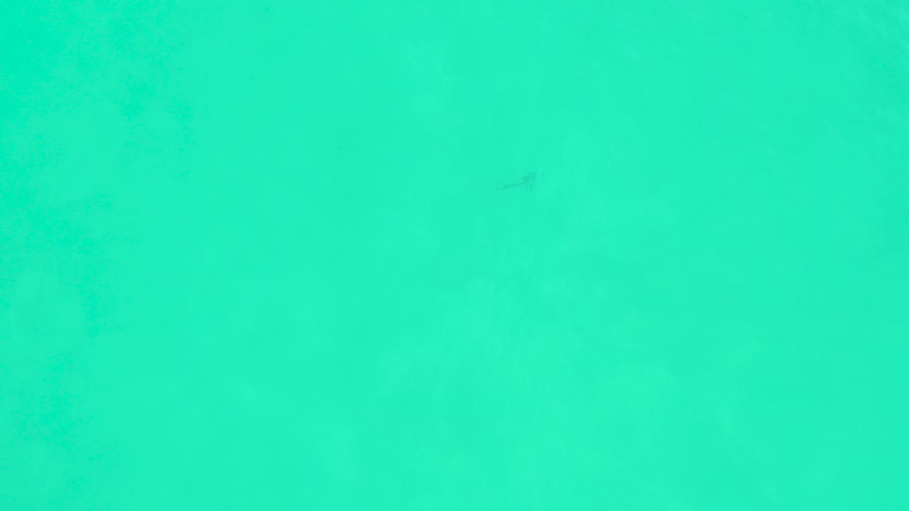 Clear turquoise water at Marquis Los Cabos, Mexico, with faint dark fish shapes and no visible people at the opening moment.