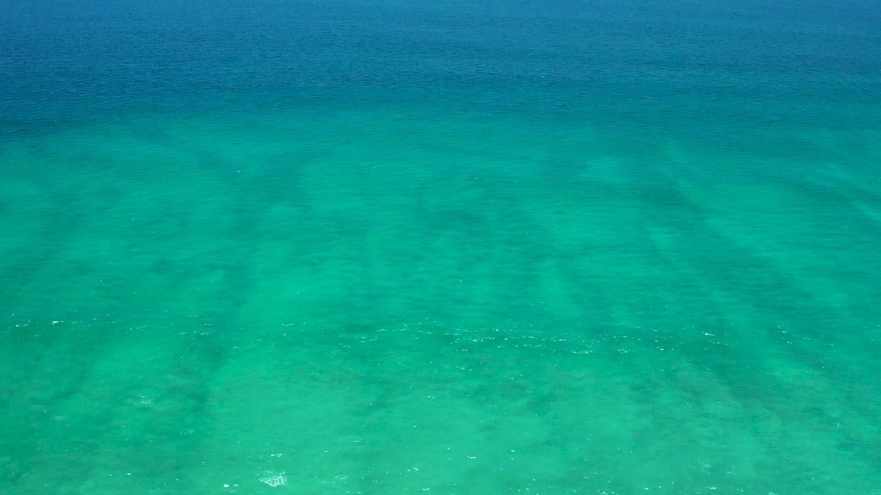 Turquoise shallow water over a sandy seabed.