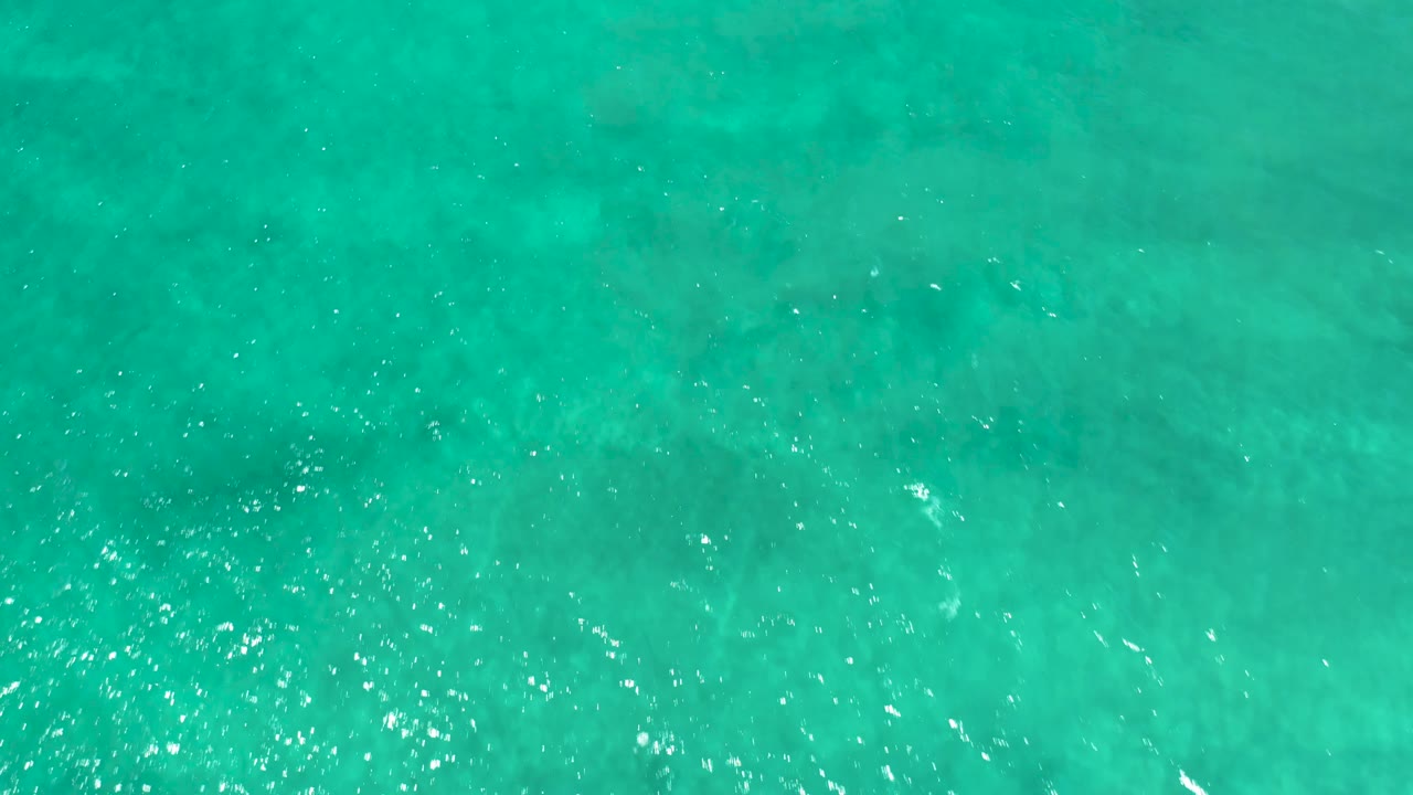 Turquoise water in San Jose del Cabo Estuary fills the shot with broad shallow ripples and faint underwater tonal variation, with no visible people.