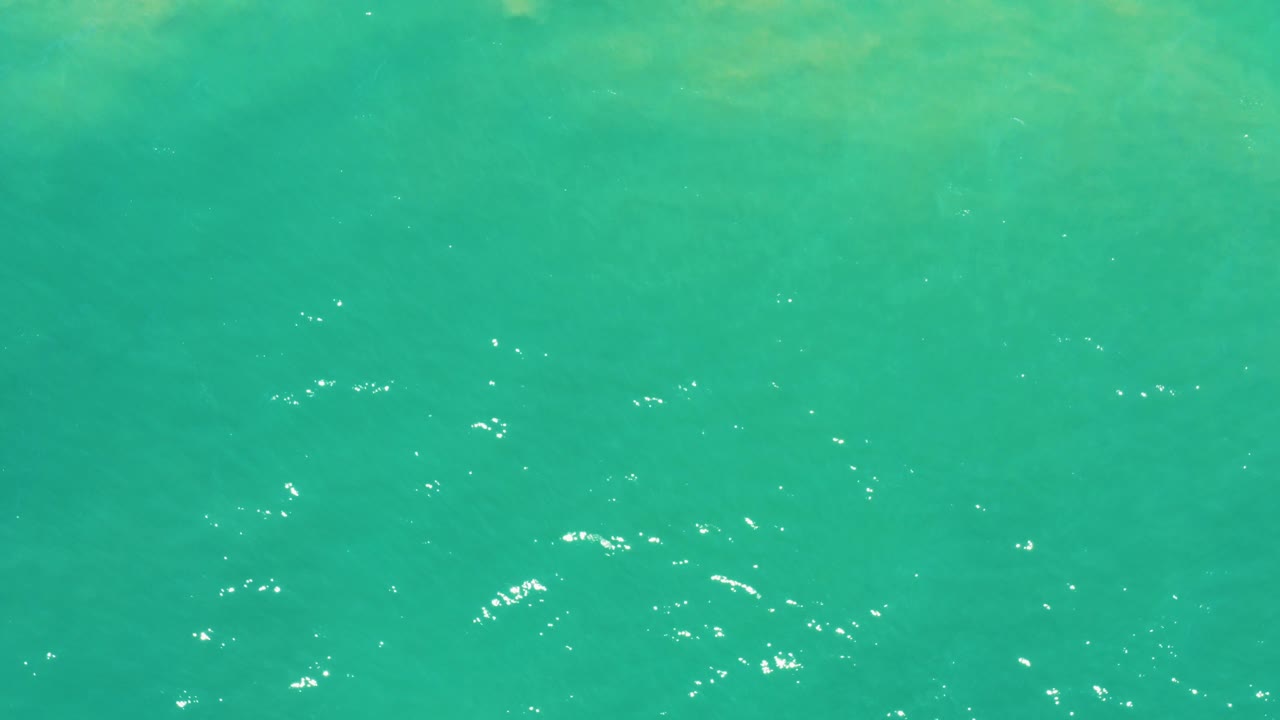 Turquoise water surface with small bright ripples.