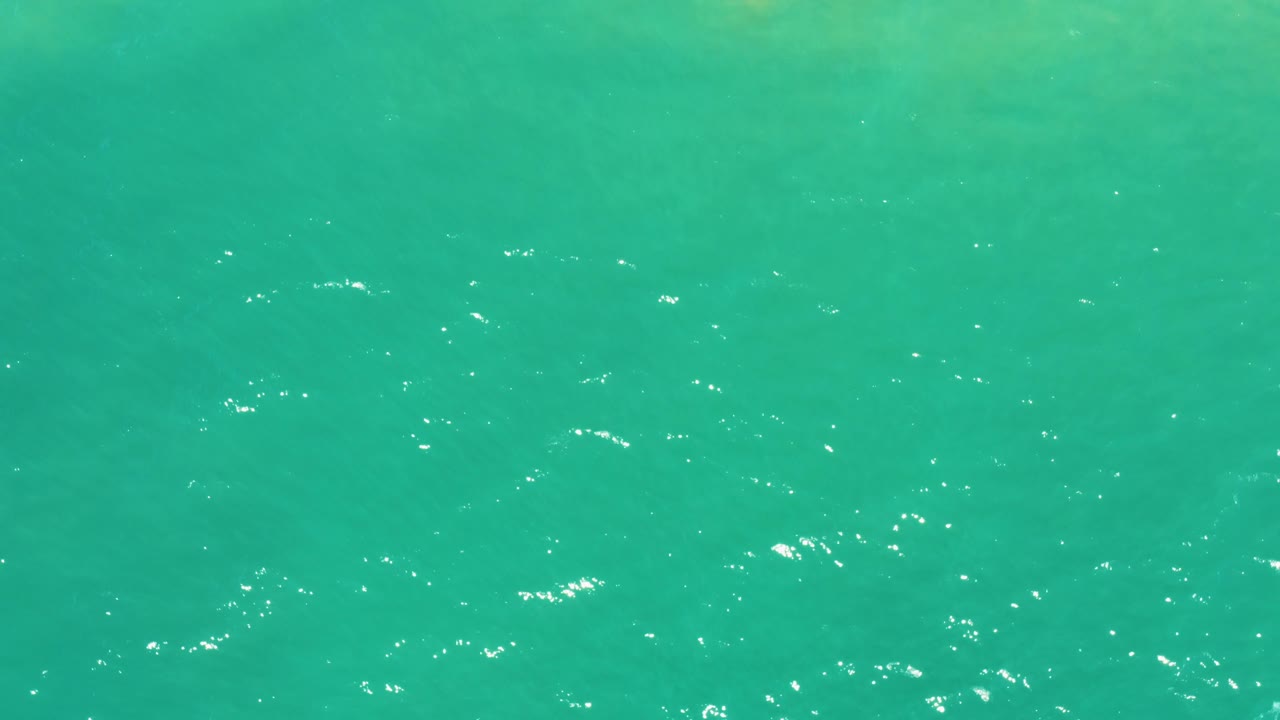 Calm turquoise water in San Jose Del Cabo Estuary fills the frame, with softer ripples and fewer bright highlights than earlier frames, no visible people.
