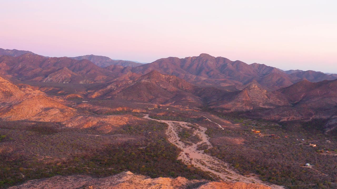 Aerial view of a desert mountain valley at sunset
