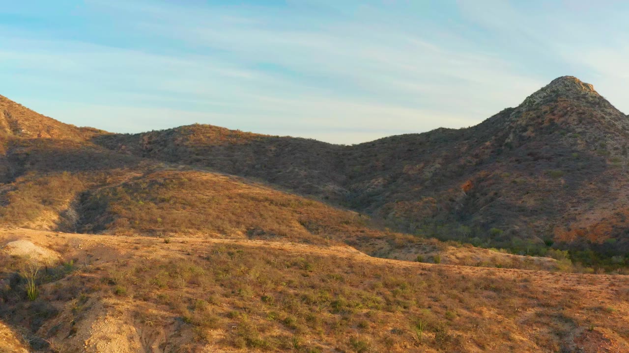 Dry hills under a pale blue sky