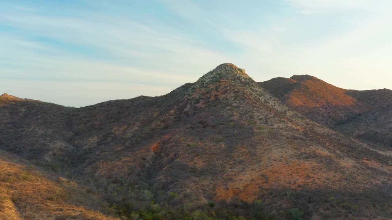 Rocky mountain slope with valley brush below