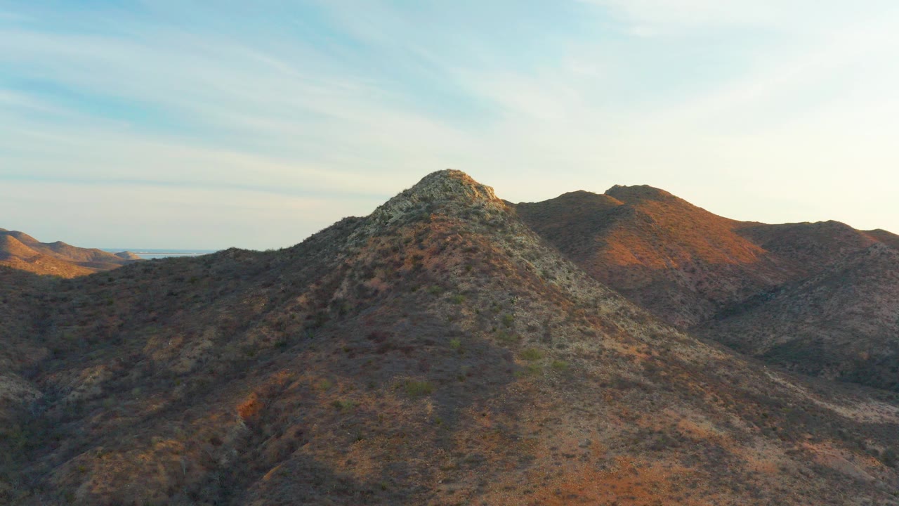 Rocky desert mountain ridge under pale blue sky