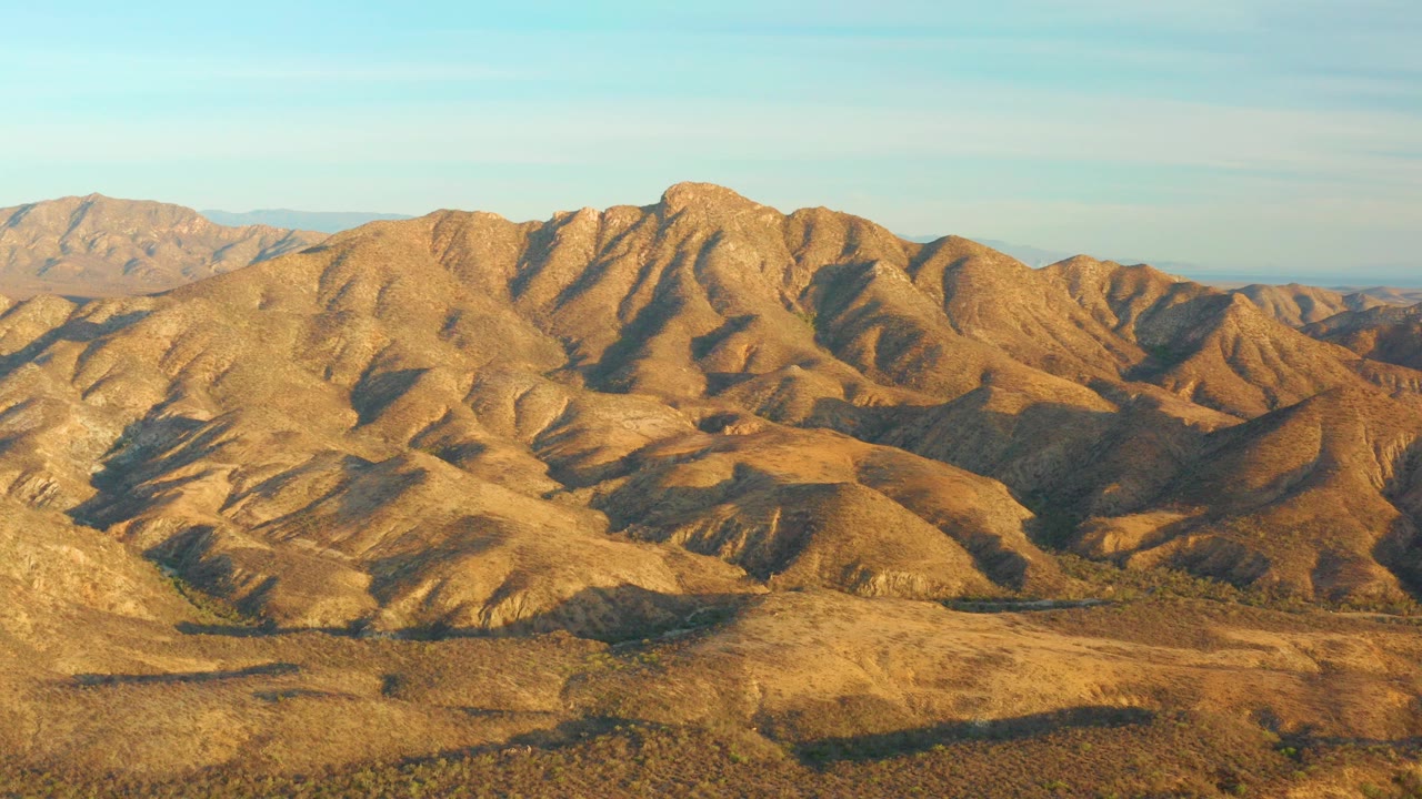 Cabo Pulmo, Baja California Sur desert hills fill the frame in warm light beneath a clear sky, with no visible people.
