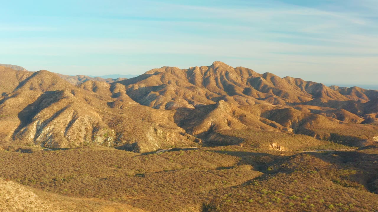 Fourth frame shows the aerial view slightly later, with a pale foreground slope entering the lower left, sunlit ridges across Cabo Pulmo, and no visible people.