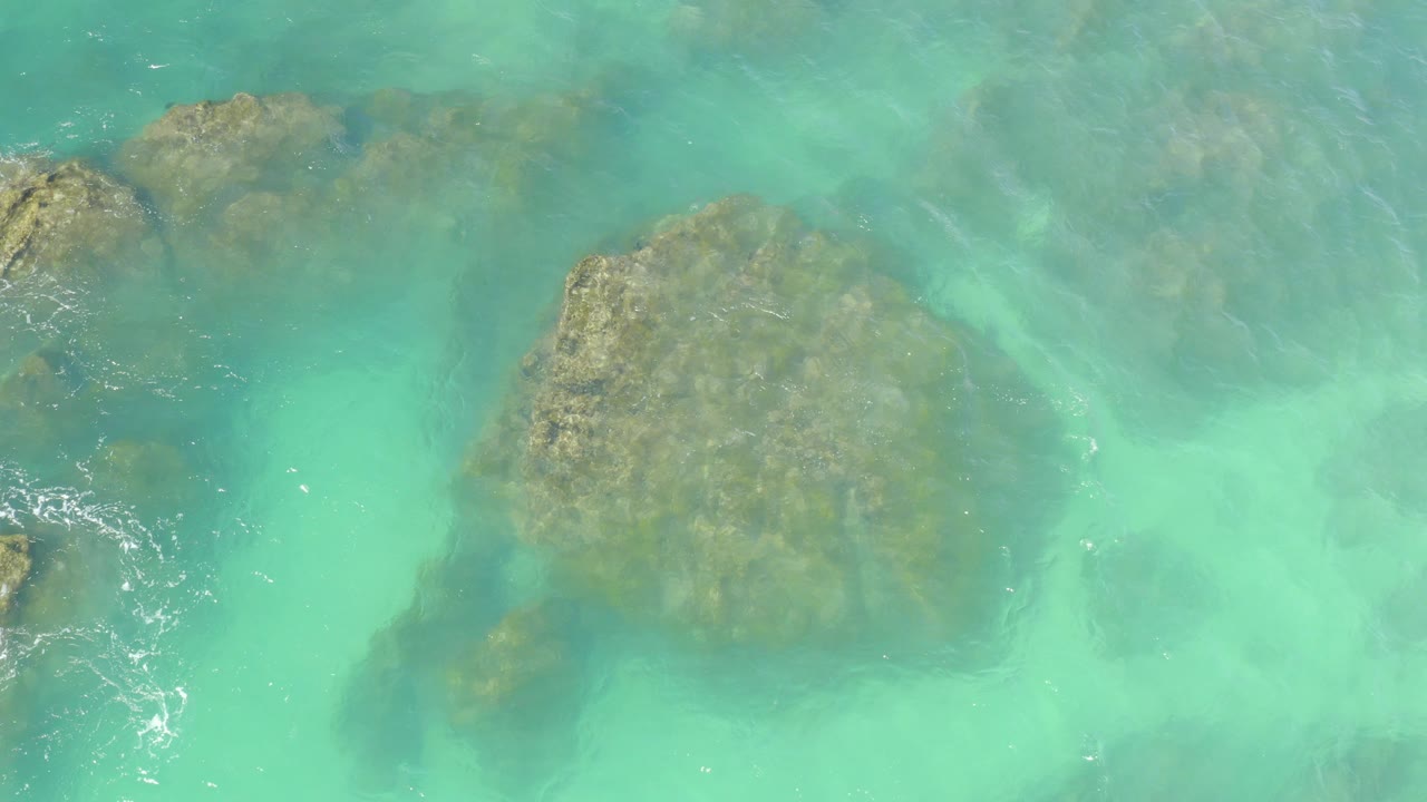 Clear turquoise water over submerged rocks