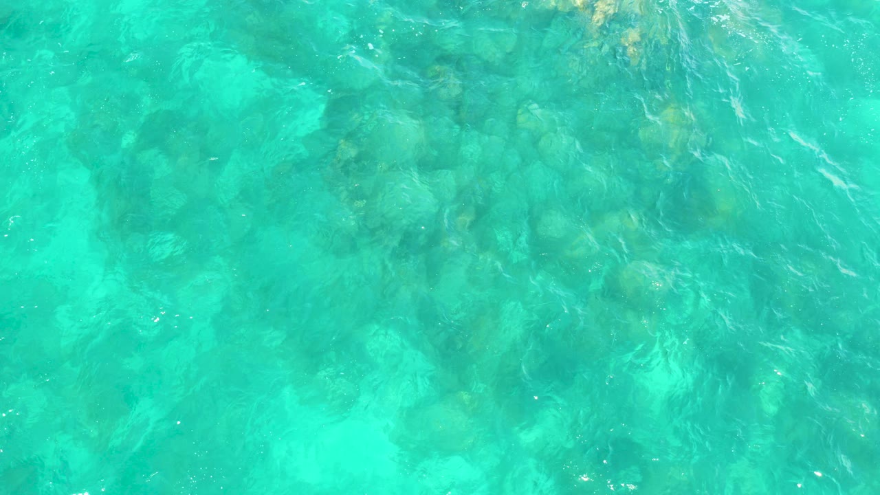 Turquoise shallow water over a rocky seabed.