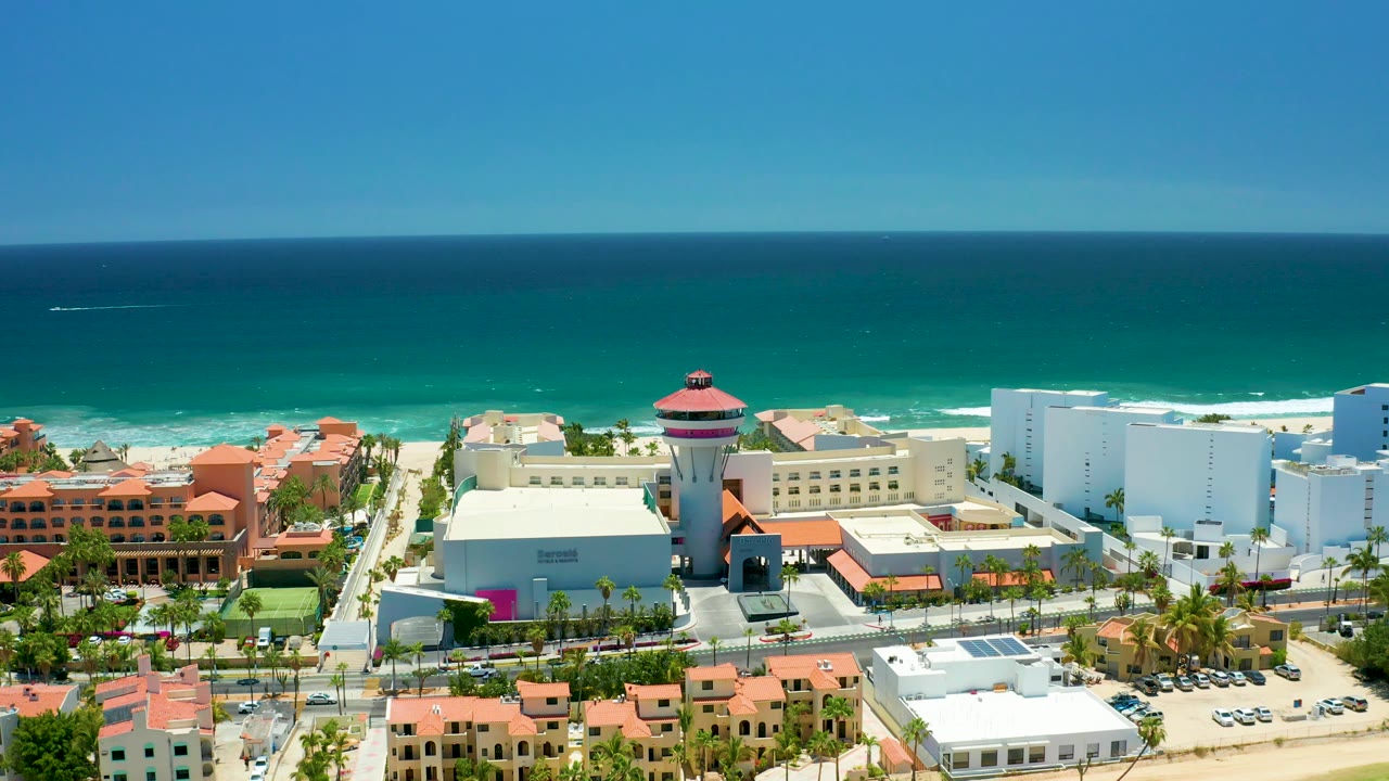 Aerial view of shoreline buildings and blue ocean horizon.