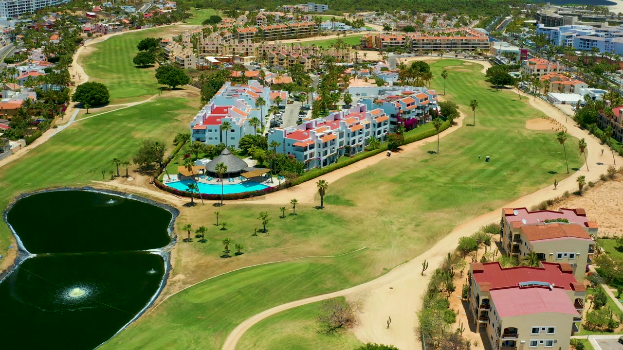 Elevated view over ponds, fairways, paths, and resort-style housing.