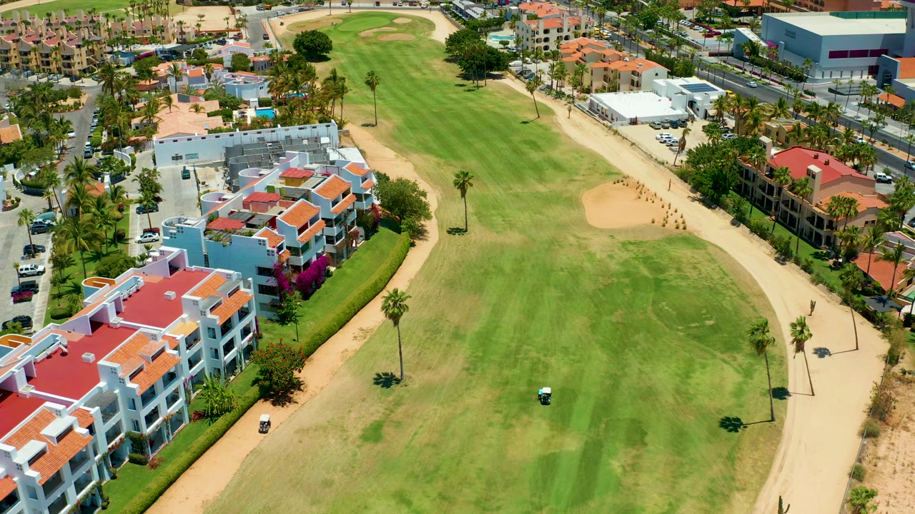 Drone view over fairway, cart path, and residential buildings