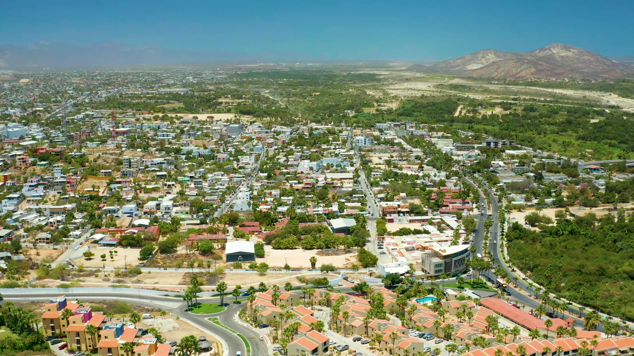 Residential blocks, a main road, green corridor, and hills seen from above.