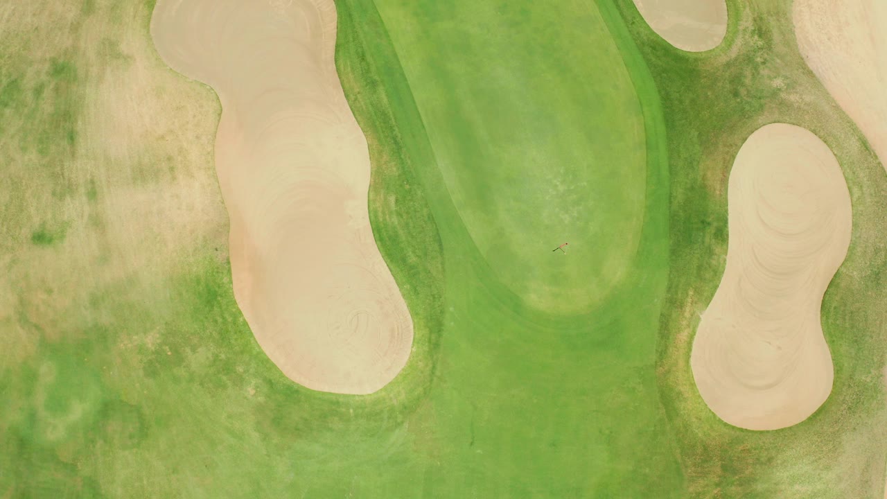 Top-down view of a San Jose del Cabo putting green framed by pale sand bunkers and dry grass, with no visible people.