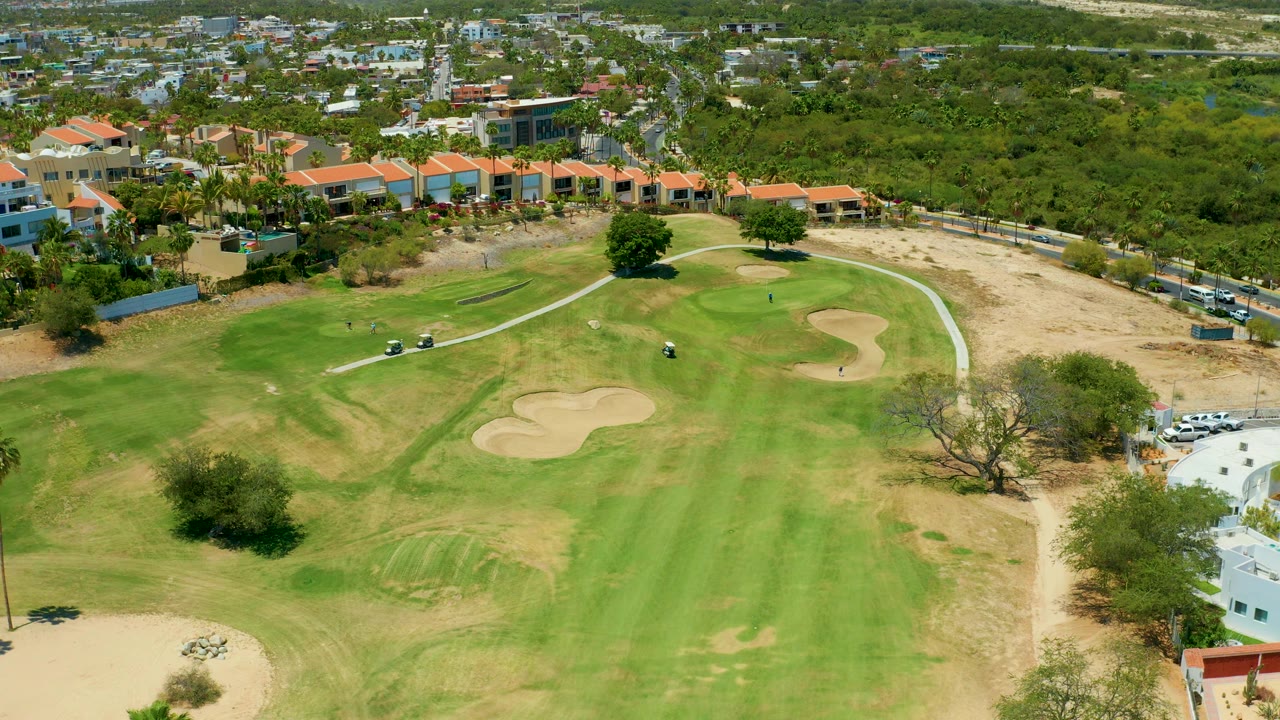 Golf green and surrounding neighborhood seen from an elevated aerial angle.