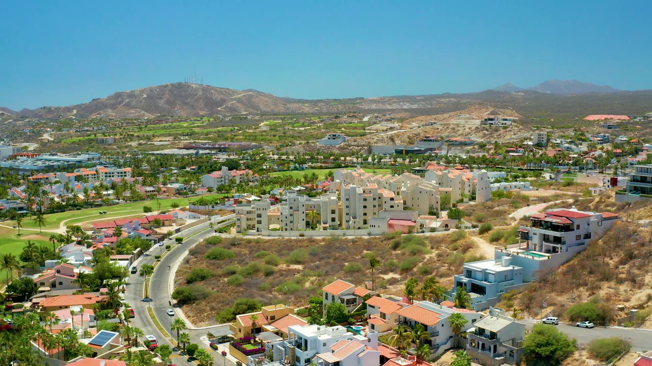 Aerial road cutaway over suburban homes and green corridors