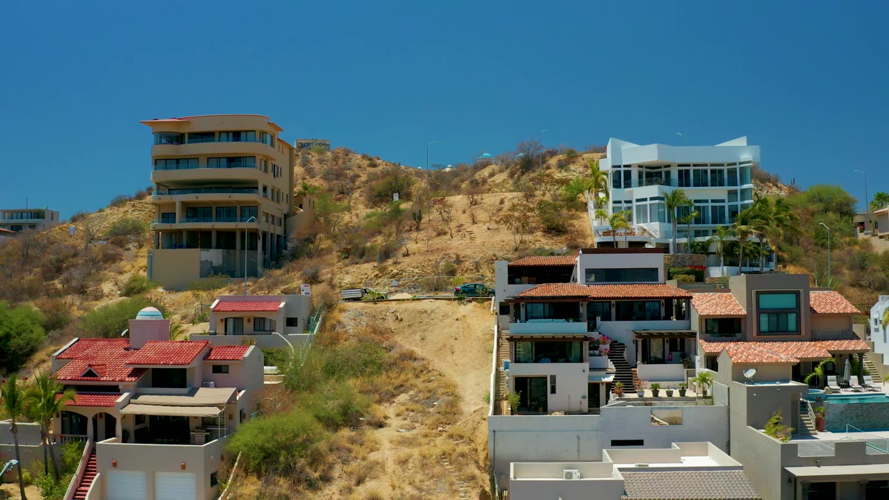 Modern hillside homes with red roofs and terraces