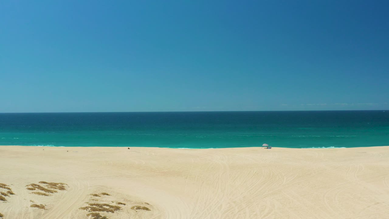 Broad blue sky over empty beach and ocean