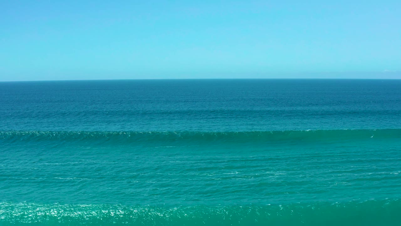 Ocean wave crest stretching across turquoise water