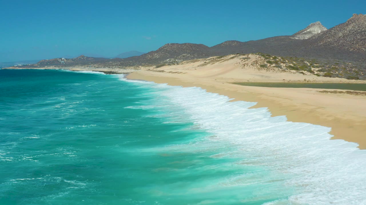 Aerial beach view with turquoise water and waves washing ashore