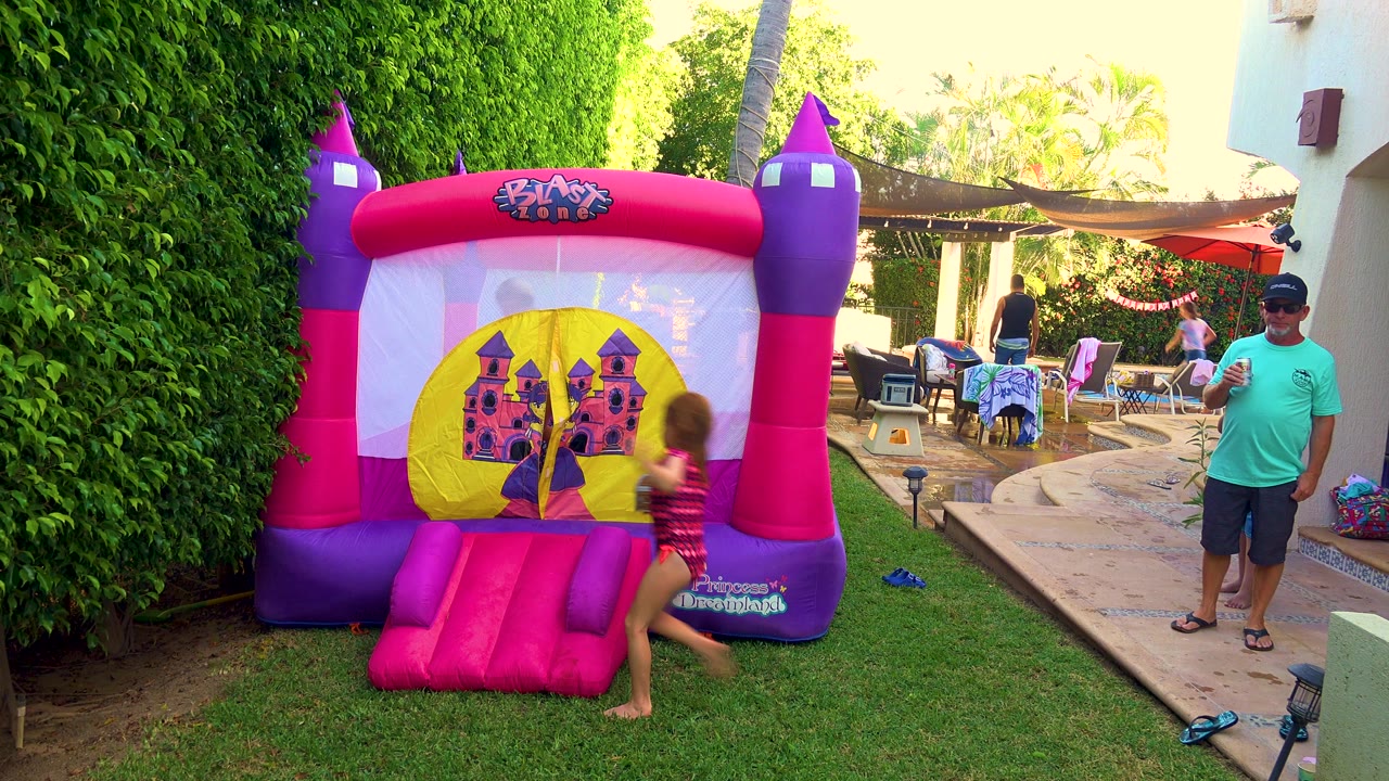 Child nears the entrance ramp of a castle bounce house.