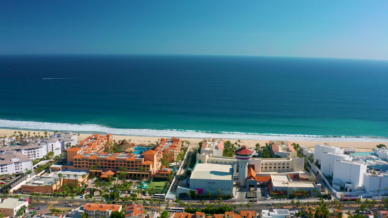 Aerial view of ocean, beach, and beachfront buildings.
