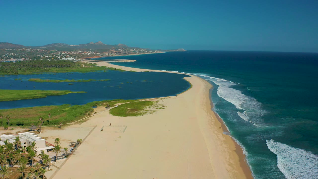 Aerial coastline with lagoon on left and surf on right.