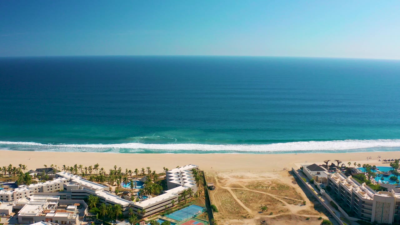 Aerial beach resort view with ocean waves and sandy shoreline