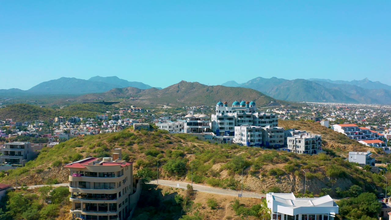 Hillside residential area with foreground building and distant city