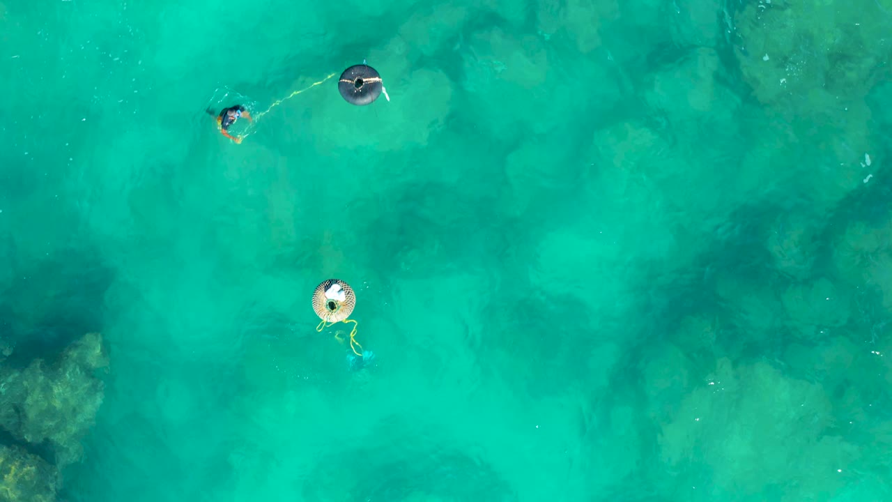 Two floaters spaced apart over shallow blue-green water.