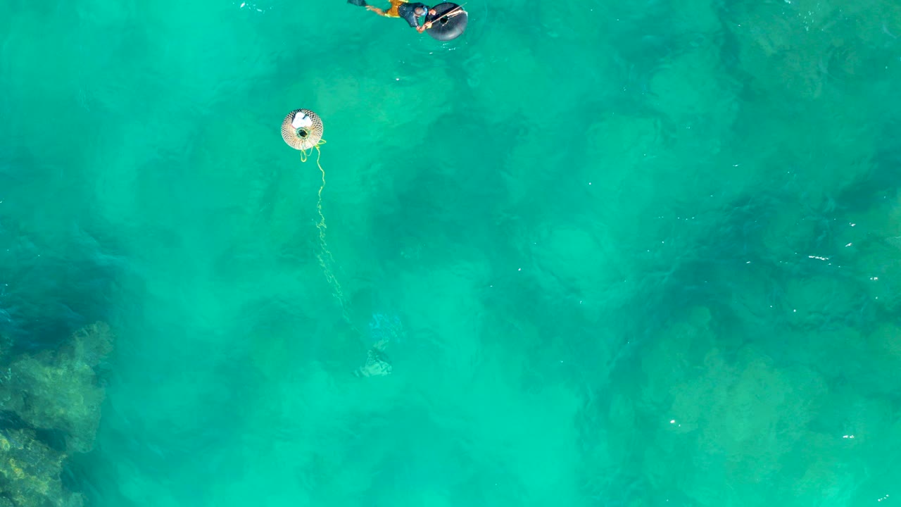 Overhead turquoise water with a buoy and a snorkeler near the top edge.