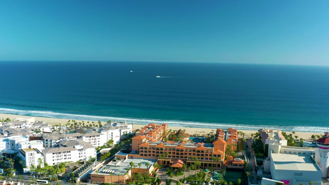 Wide aerial coastline with buildings along the lower frame