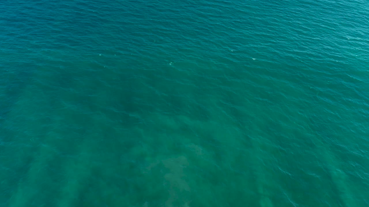 Open turquoise ocean surface with underwater shadows
