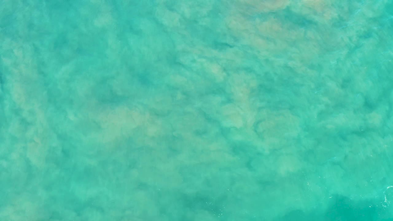 Clear blue-green shallow water in San Jose del Cabo, Mexico, with faint ripples crossing a sandy bottom and no visible people.