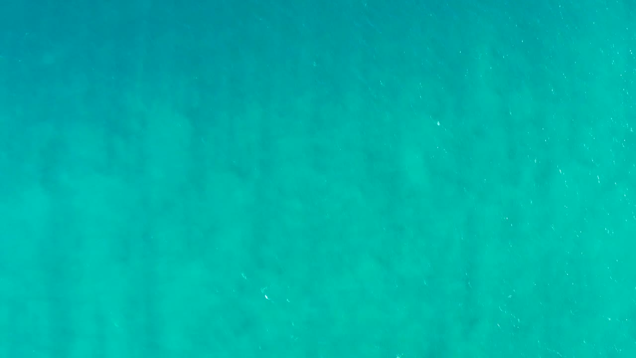 Clear turquoise water in San Jose Del Cabo, Baja California Sur, looking down at a muted sandy seabed with no visible people.