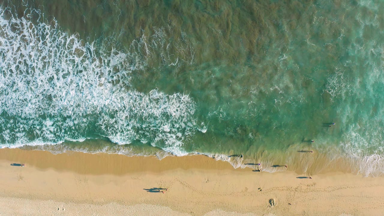 White wave foam advancing over shallow turquoise water