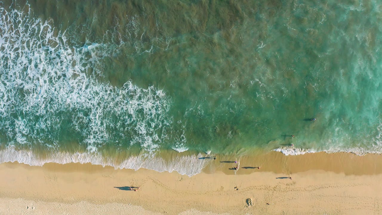 Aerial beach with surf pulled across wet sand