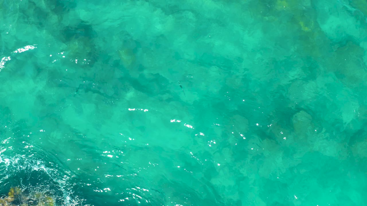 Turquoise water with a rocky edge entering the lower corner.